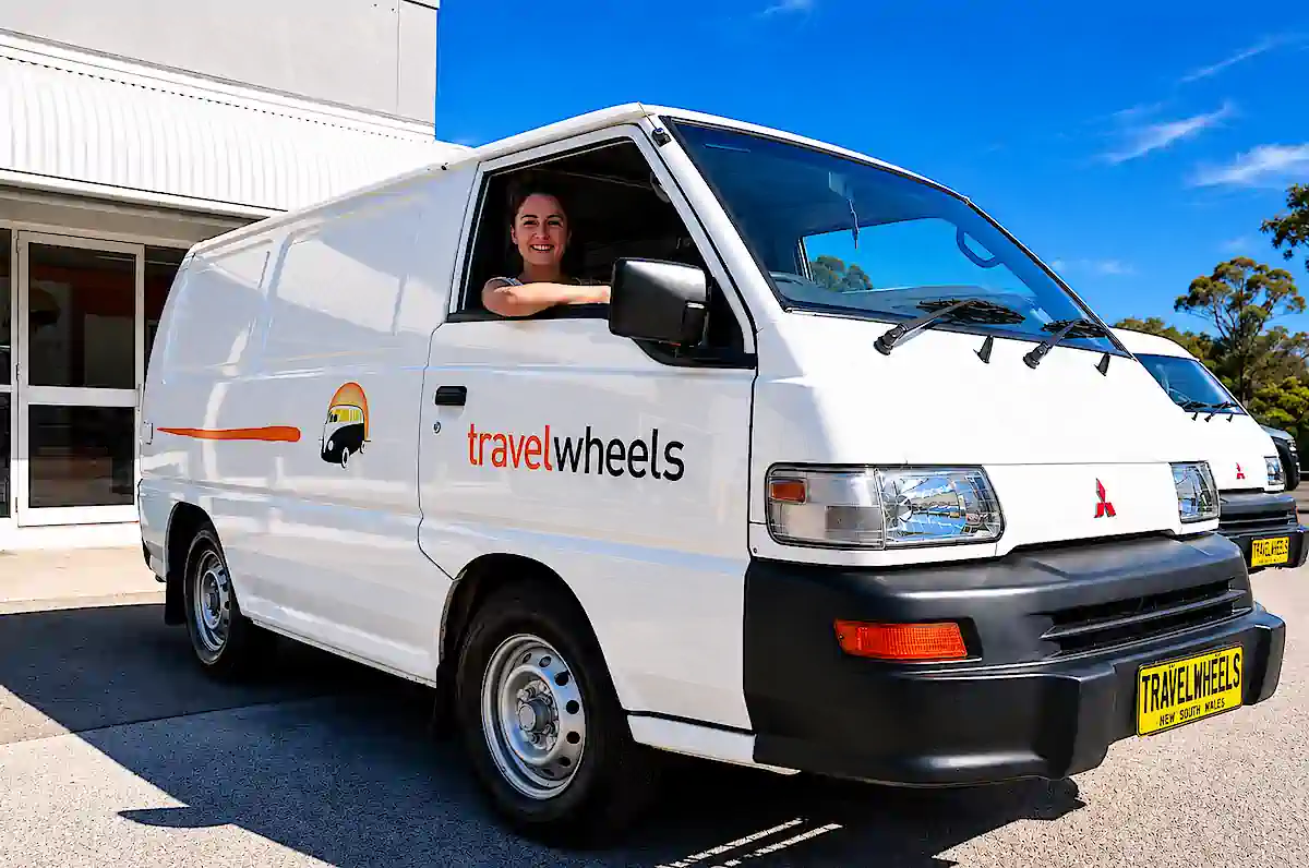 Campervan à vendre à Sydney chez Travelwheels avec cliente au volant devant notre dépôt de Botany