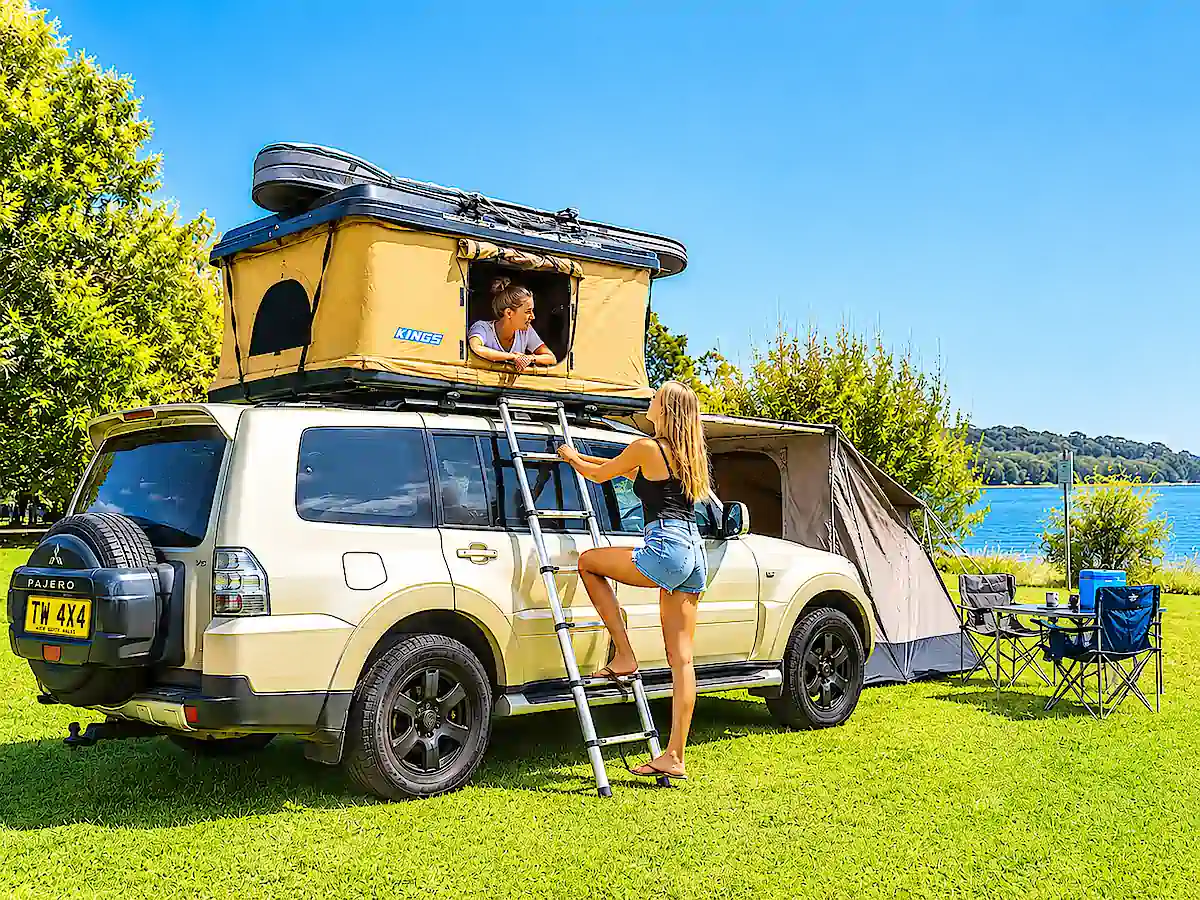 Mitsubishi Pajero à vendre avec tente de toit ouverte et deux voyageuses en camping en Australie
